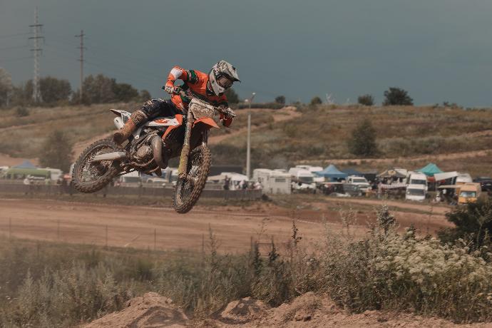 man riding dirt bike in mid air during day